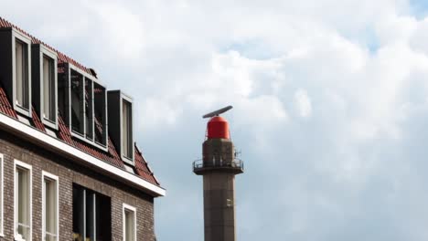 windmill with iconic dutch homes and cloudy but blue sky