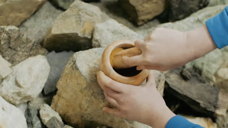 grinding spices outdoors with mortar and pestle