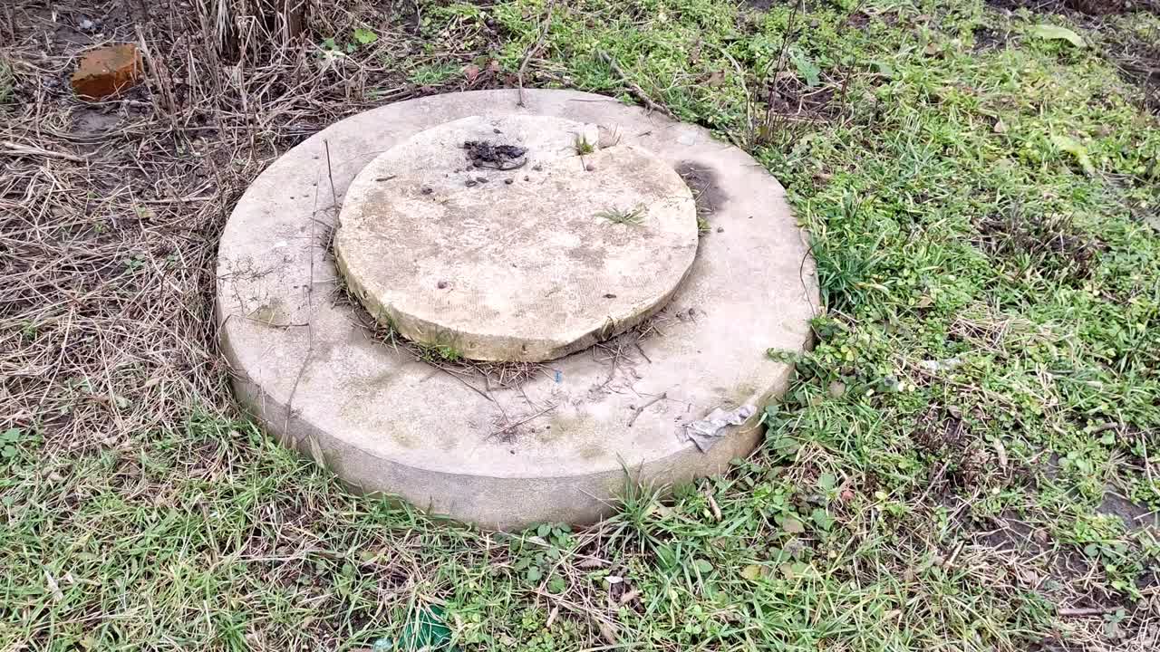 Septic tank hatch on the ground in the garden