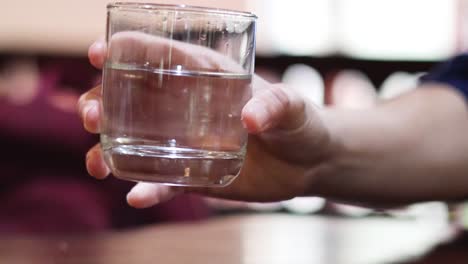 sequence of a hand lifting a glass of water