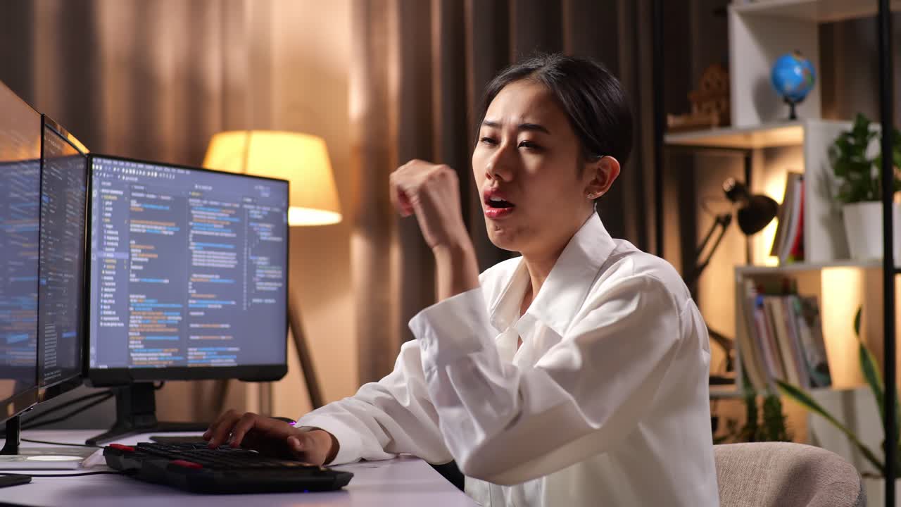 Asian Woman Programmer Yawning And Sleeping While Creating Innovative Software Engineer Developing App, Program, Video Game On Desktop Computer At Home. Terminal With Coding Language
