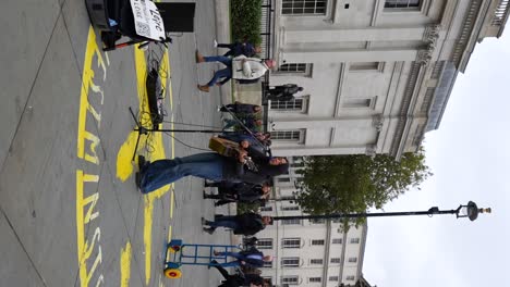 leire jamming on guitar and singing at trafalgar square, london. vertical shooting