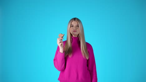 Sweet-young-woman-treats-herself-with-a-chocolate-cookie,-isolated-studio-shot