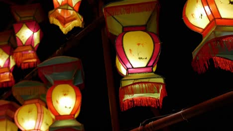 las luces de las linternas chinas cuelgan mientras la cámara pasa rápidamente contra un cielo nocturno