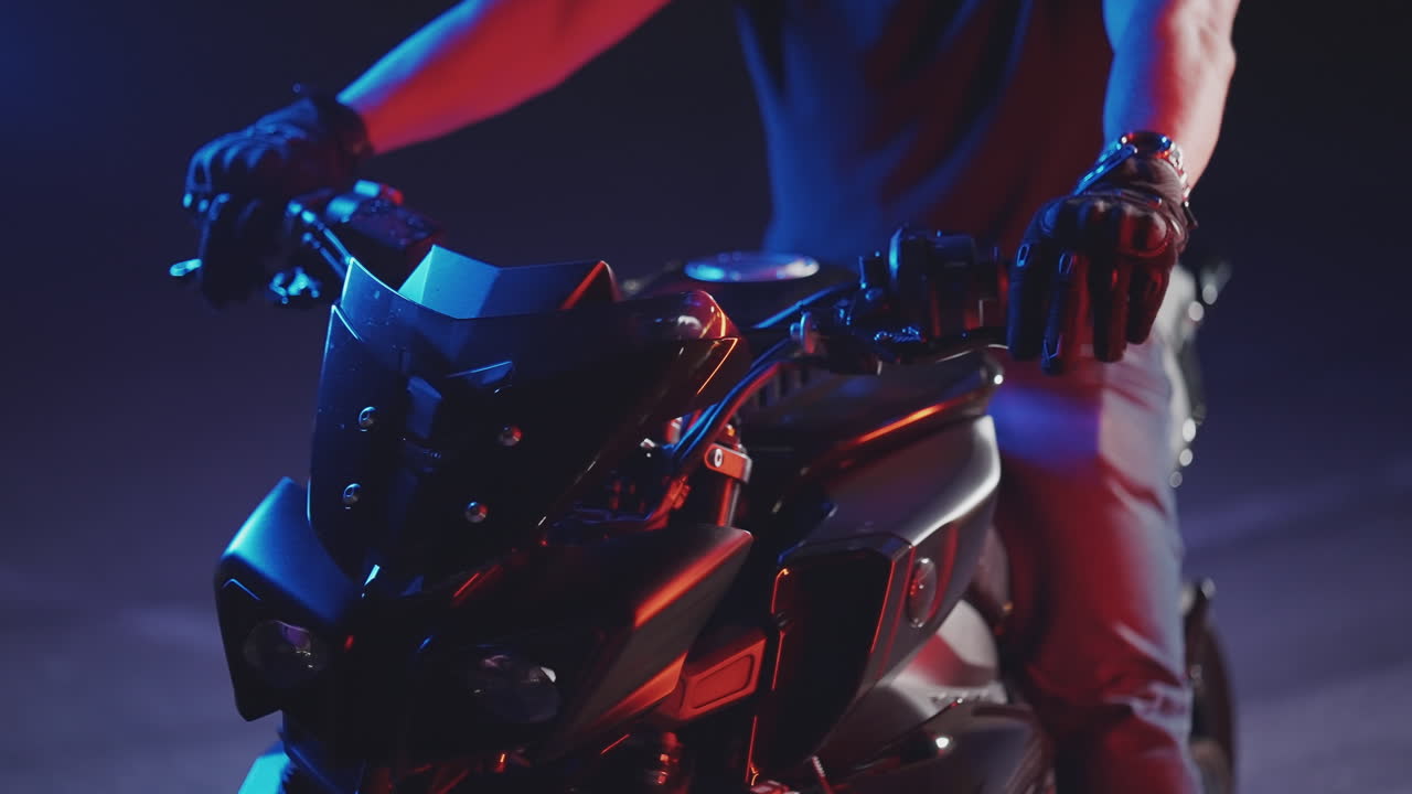 밤에 검은 모터사이클을 타고 있는 남자