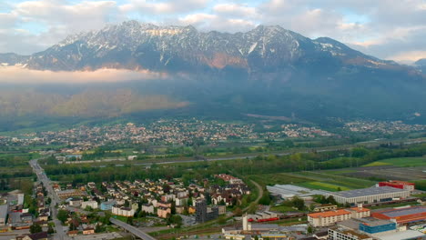 scenic view over swiss town with mountains in background in switzerland - aerial drone shot