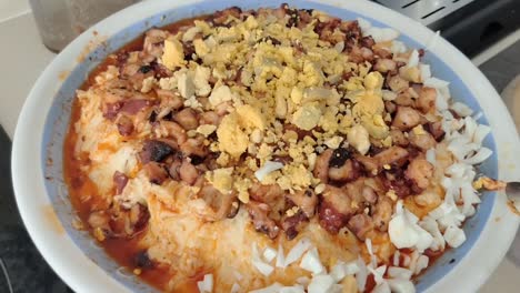 primer plano de una mano en una cocina doméstica añadiendo ingredientes a una tradicional ensalada de pulpo del sur de españa