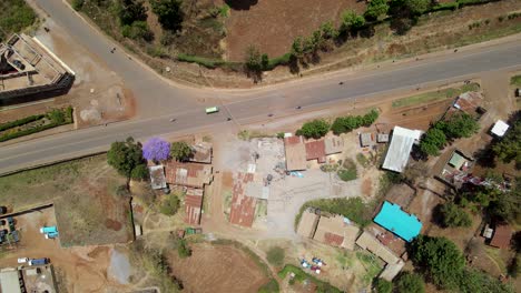 Aerial-view-of-a-town-and-sunlit-fields,-golden-hour-in-rural-Africa---tracking,-drone-shot