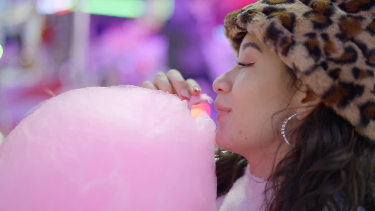 Woman Eating Cotton Candy at a Night Market