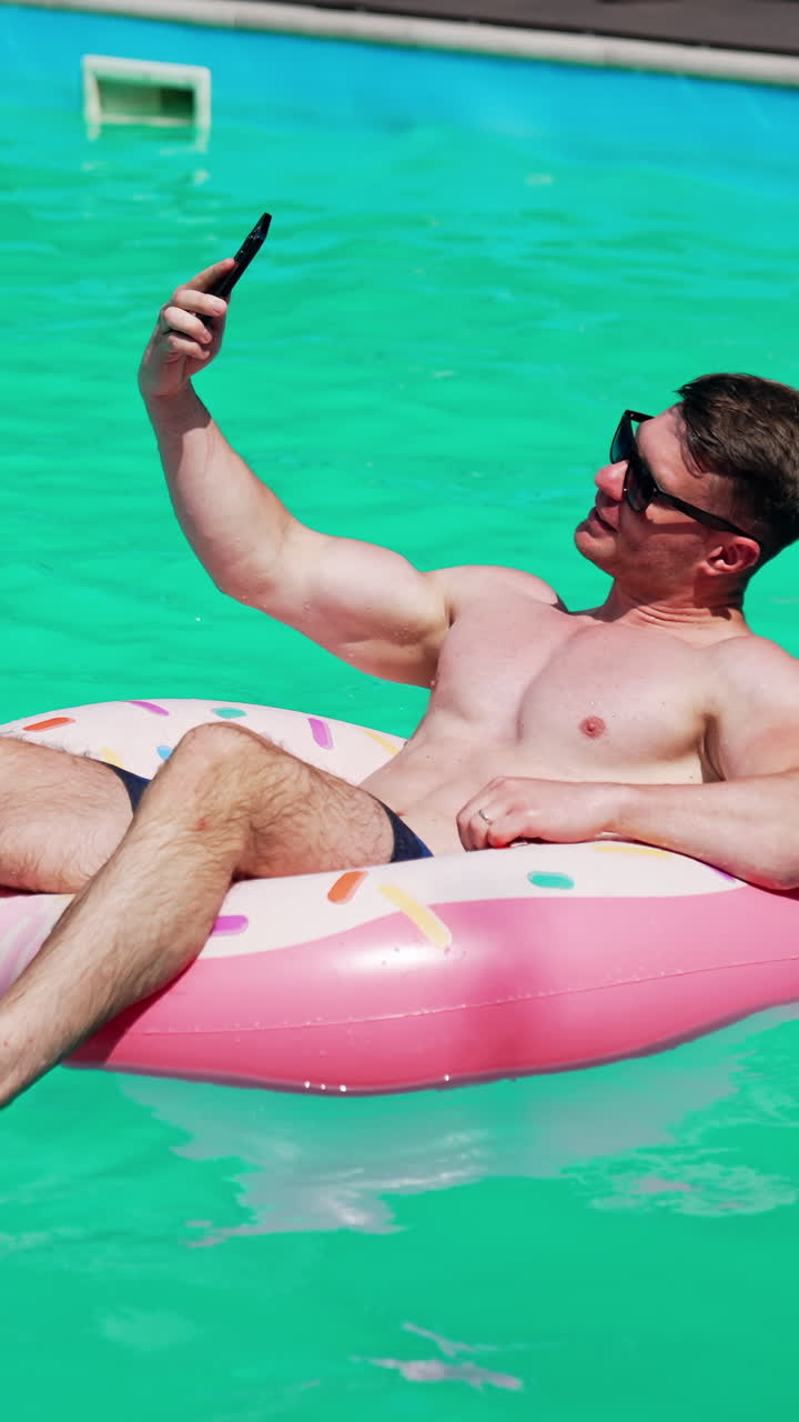 Summertime vaction man in pool having fun. Water fun in sunny summer day.