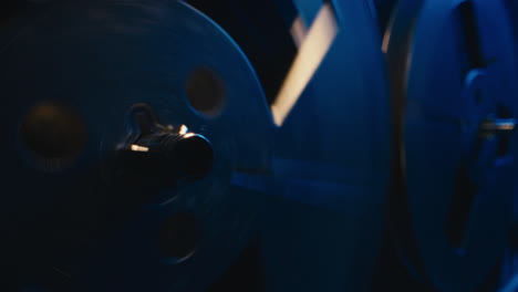 a vintage tape recorder spinning spools in a blue light