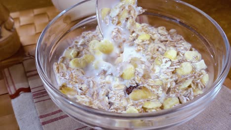 Muesli-De-Cereales-Integrales-En-Un-Tazón-Para-Un-Delicioso-Desayuno-Con-Leche-Por-La-Mañana.-Cámara-Lenta-Con-Seguimiento-De-Rotación.