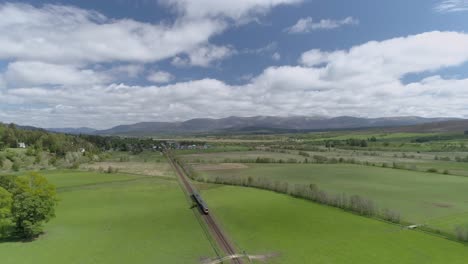 seguimiento aéreo de un tren scotrail que se dirige hacia newtonmore en escocia