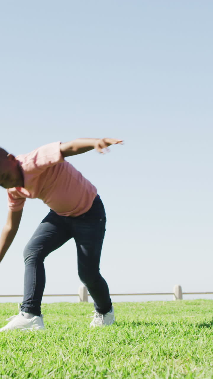 video de un feliz niño afroamericano haciendo rueda de carreta al aire libre