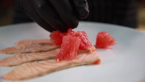 chef preparando un plato de salmón con pomelo