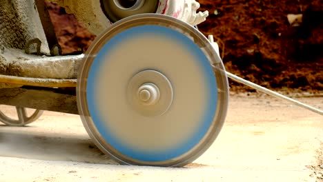 closeup cutting concrete floor with diamond saw blade machine at construction site.worker cutting concrete road by electric cutting machine.