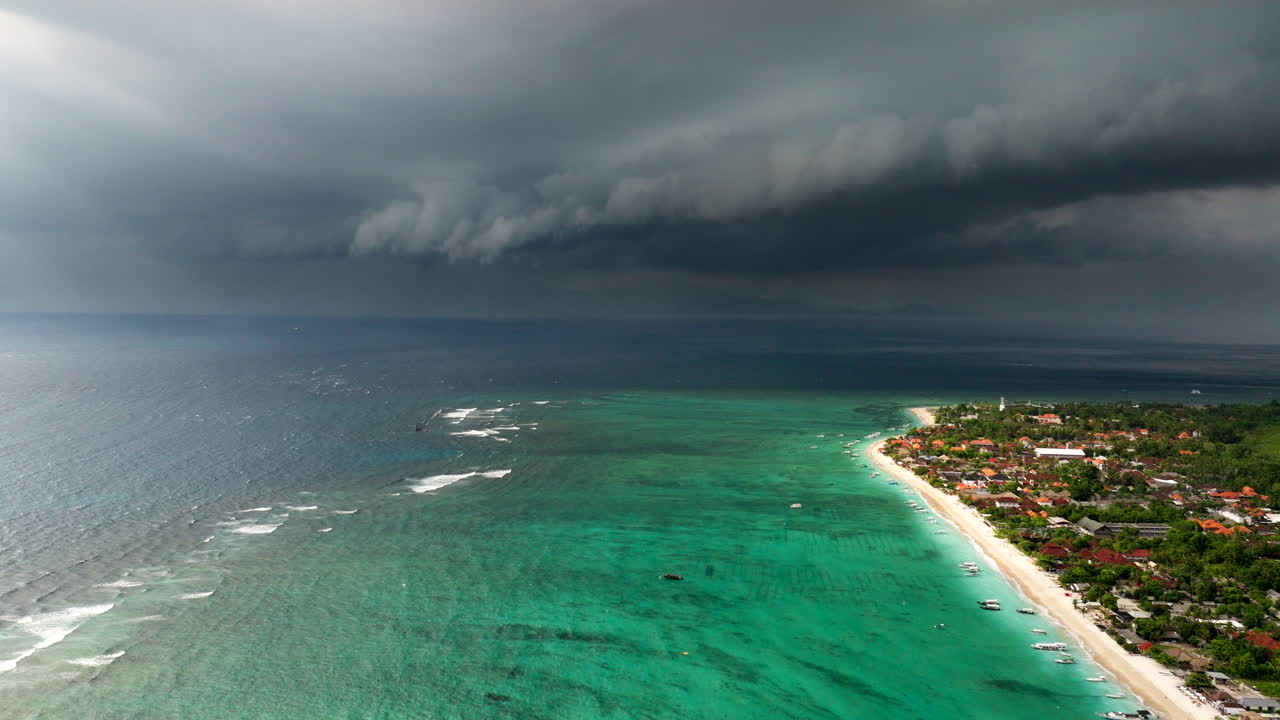 인도네시아의 누사 렘본간 (nusa lembongan) 의 푸르키즈색 바물 위에 있는 폭풍우와 검은 구름의 색 대조