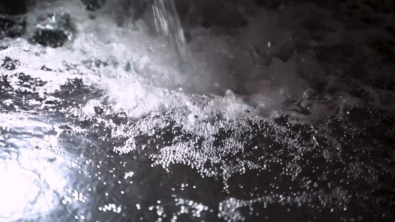 맑은 조명 수영장으로 튀는 물줄기