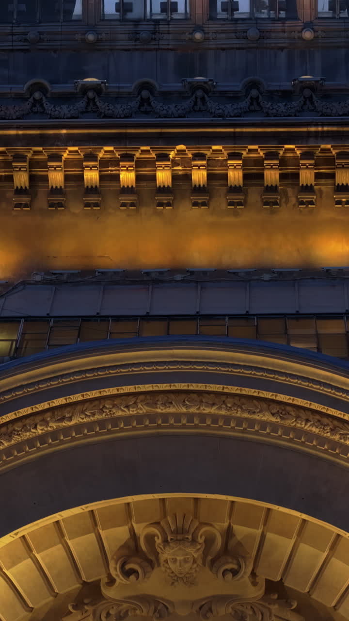 Vertical aerial drone view of the illuminated Palace of the Deposits and Consignments in the evening. Blue hour in Bucharest, Romania