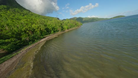 Drone-flying-through-trees-towards-the-lagoon-at-Le-Morne-Brabant