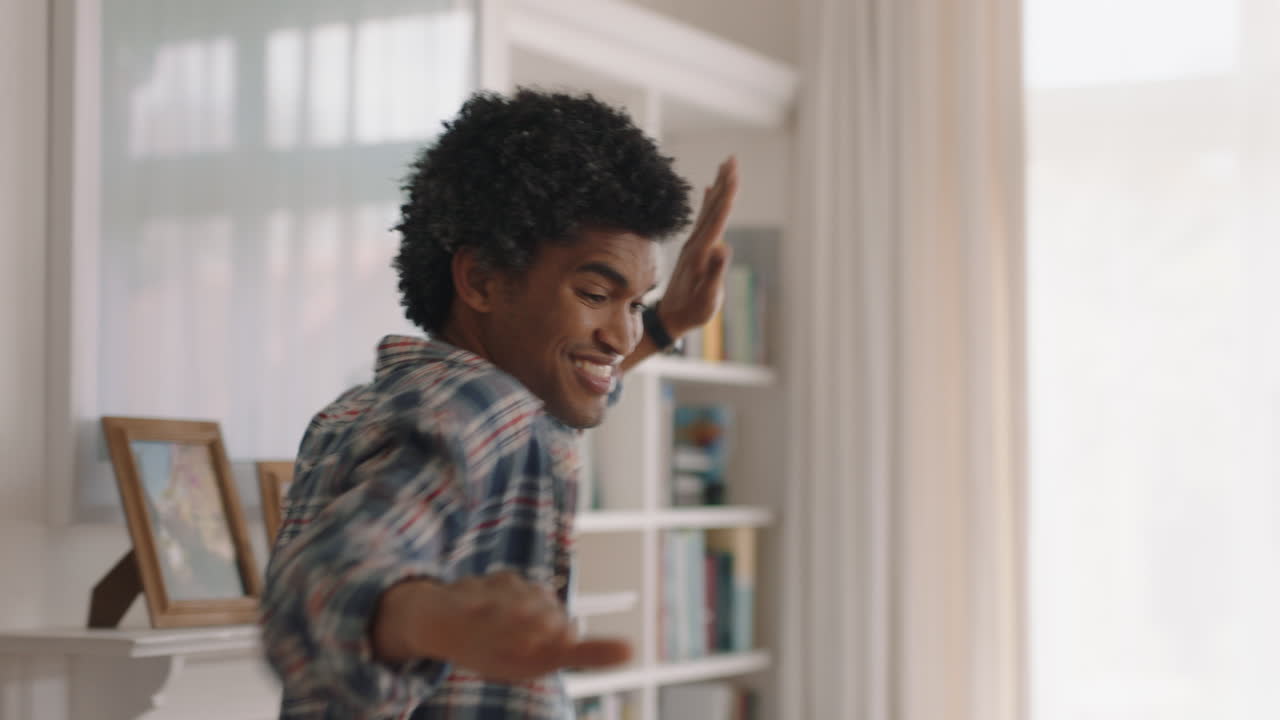 happy young man dancing at home having fun celebrating with funny dance moves enjoying freedom on weekend 4k footage