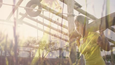 animation of grass over diverse women at obstacle course carrying wooden bars