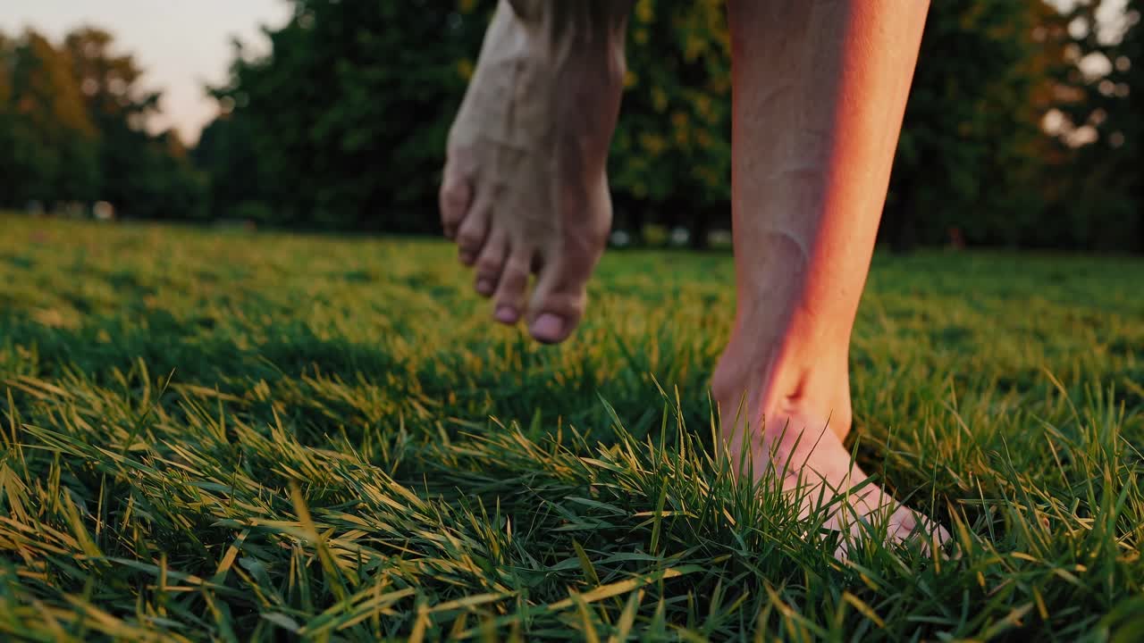 Bare Feet Walking on Green Grass in a Park at Sunset