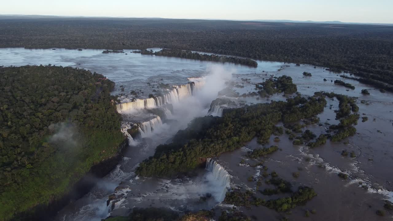 vista de pájaro de las cataratas del iguazú cerca de la frontera entre argentina y brasil al atardecer con la selva amazónica al fondo