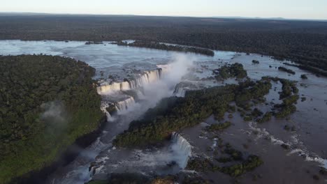 bird's eye view of the iguazu falls near the argentina-brazil border at sunset with the amazon rainforest in the background