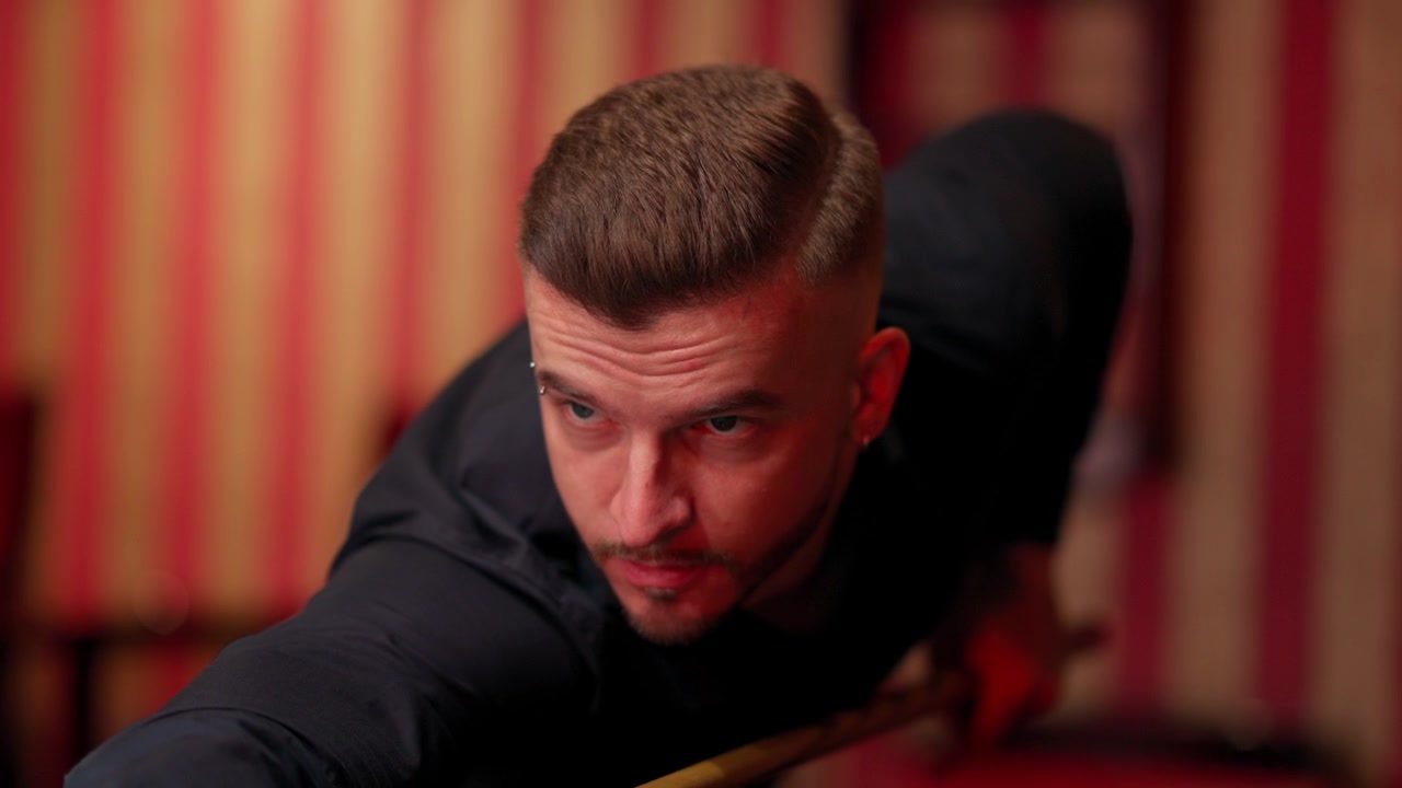 Homme concentré visant son coup au billard