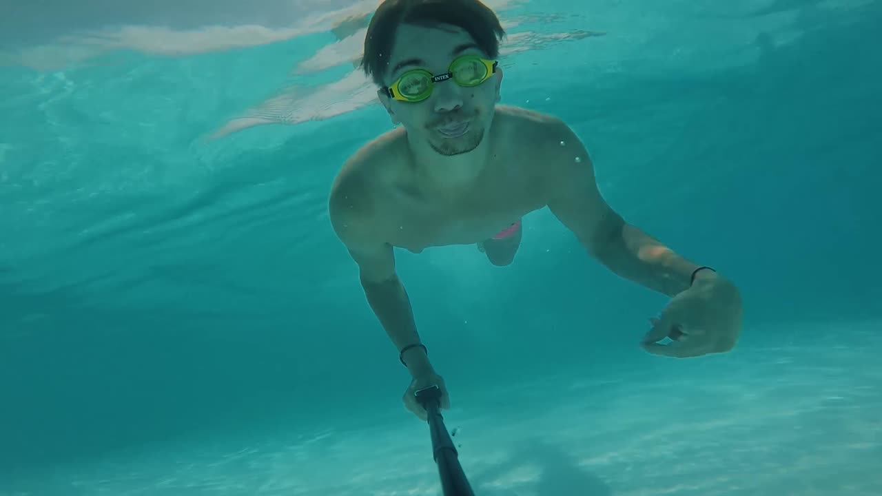 Uomo che nuota sott'acqua in piscina