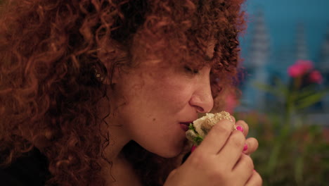 woman eating and savouring a gourmet burger made with swordfish for dinner