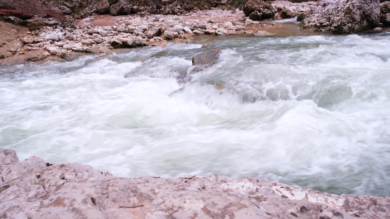 A foz de um rio rochoso de montanha corre. Corrente forte e água borbulhante, cachoeira. O conceito de turismo, caminhada, beleza da vida selvagem. 4K
