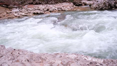 la desembocadura de un río de montaña rocosa fluye. fuerte corriente y agua hirviendo, cascada. el concepto de turismo, senderismo, belleza de la vida silvestre. 4k