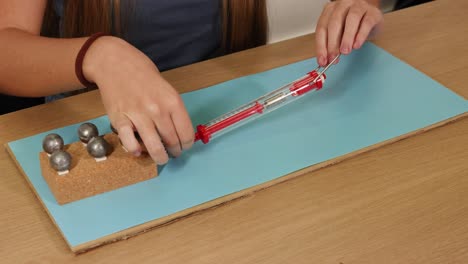 a person uses a spring scale to measure frictional force on a weighted block sliding over a surface
