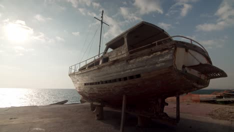 Naufragio-Varado-En-La-Arena-Cerca-Del-Mar-Día-Soleado,-Ruinas-De-Barcos-Antiguos-Barcos-Antiguos-Abandonados-Viejos-Recuerdos