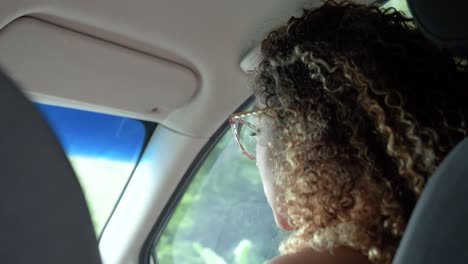 cute curly girl singing in the front seat