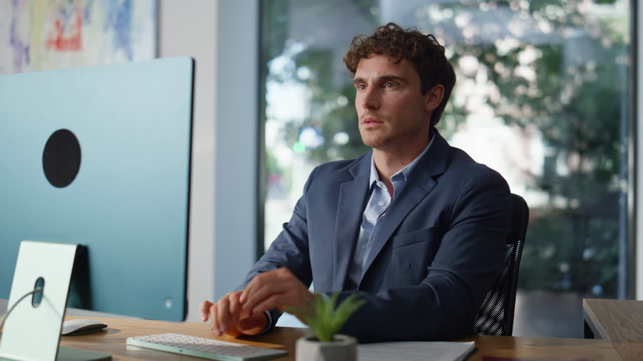 Serious executive typing email at computer sitting office workplace closeup
