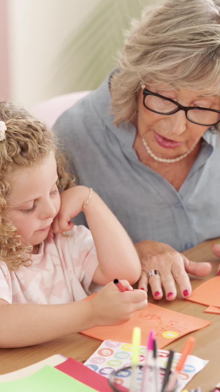 A child and her grandmother doing arts and crafts