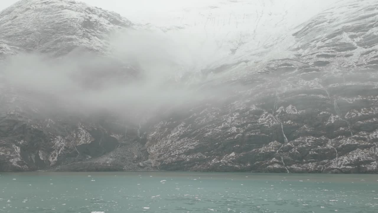 Gimbal close-up shot from a moving ship of misty mountains during winter in Glacier Bay, Alaska. 4K