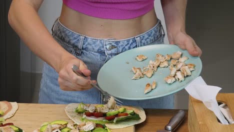 woman preparing chicken and vegetable wraps