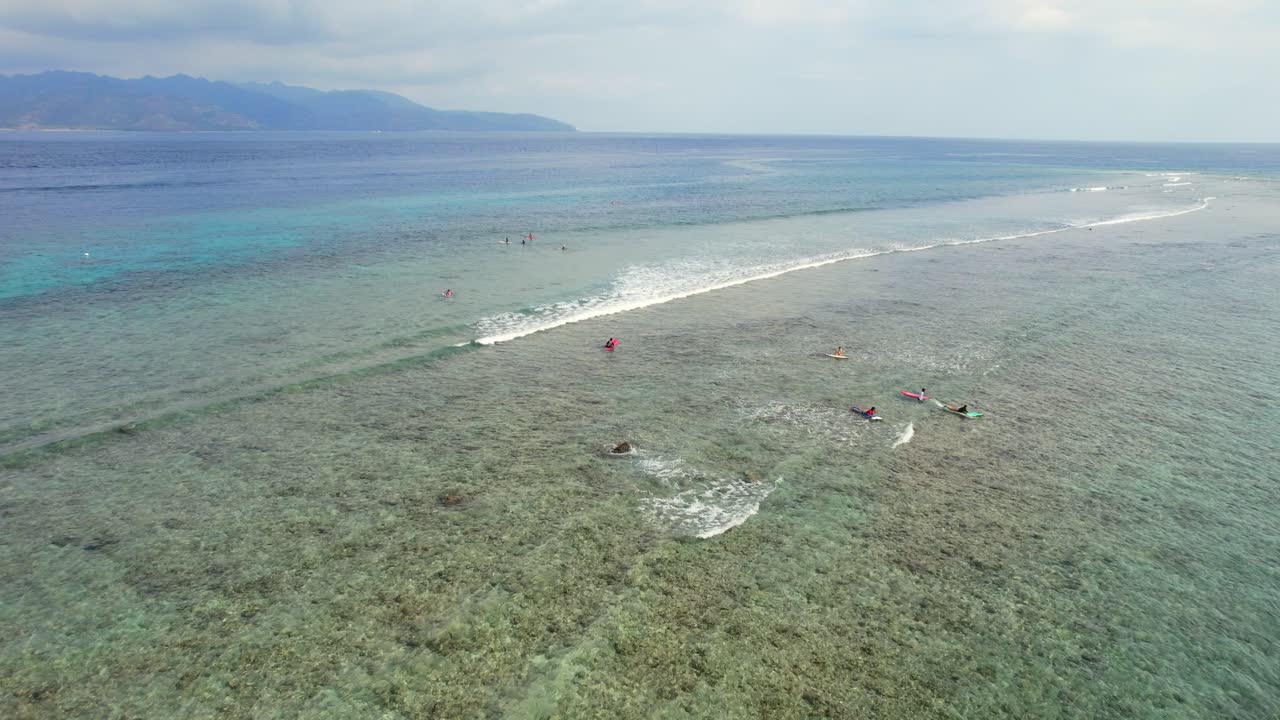 인도양 에서 작은 물결 을 잡으려고 하는 길리 섬 의 저수지 에서 서핑 하는 서퍼 들, 공중