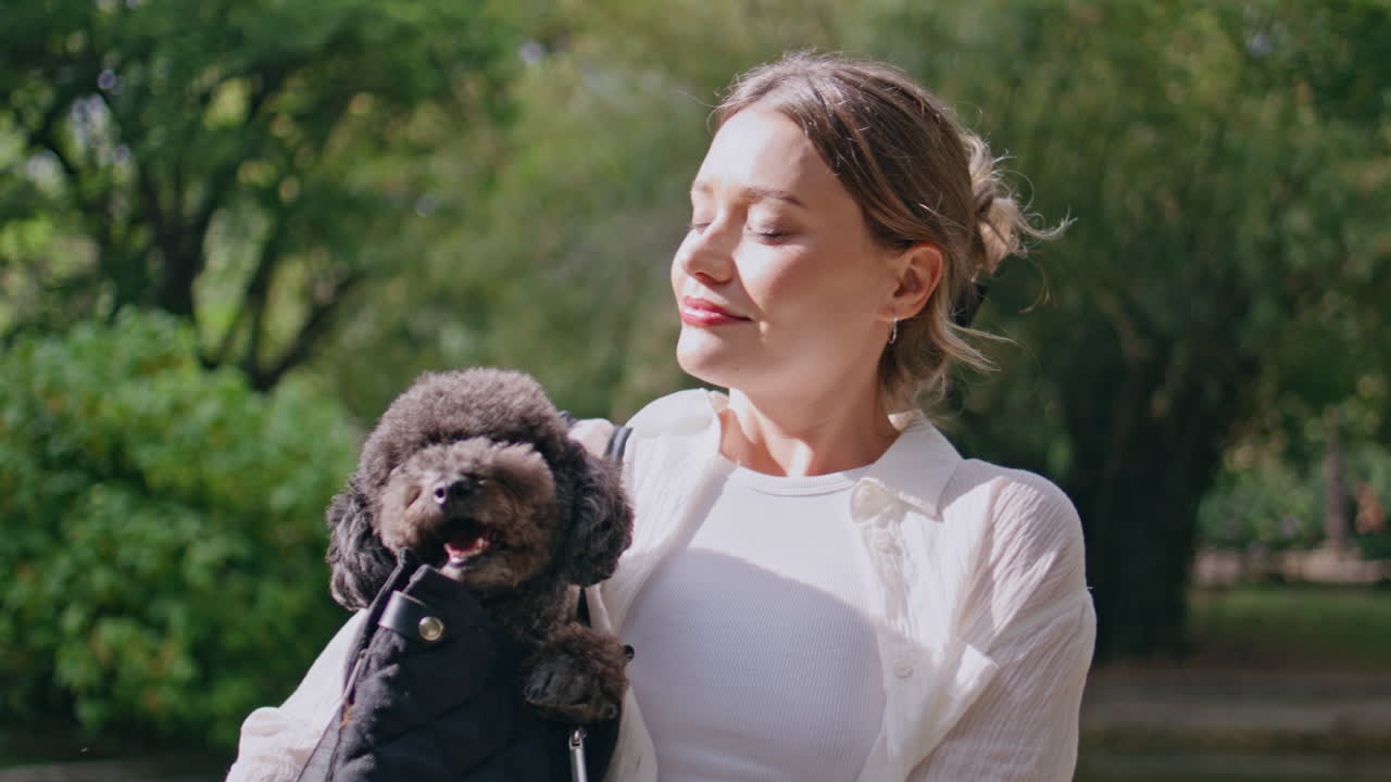 Woman basking sunlight dog enjoying summer weekend close up. Smiling girl
