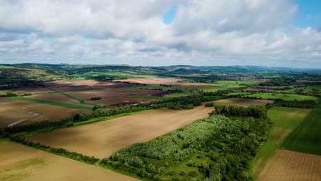 Paisaje-Aéreo-Toma-Delantera-De-Vista-Nublada-Brillante-Y-Sombreada-De-áreas-Agrícolas-Colinas-Y-Pequeño-Bosque-Verano-Condado-De-Zala-Hungría-Europa