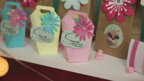 paper craft present boxes with text in spanish saying "let's be happy