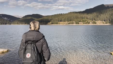 bolboci, romania - a lady taking in the natural beauty of the lake - drone flying forward