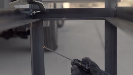 slow motion of worker using stick welder to weld steel framework