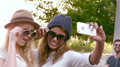 smiling attractive friends taking selfie