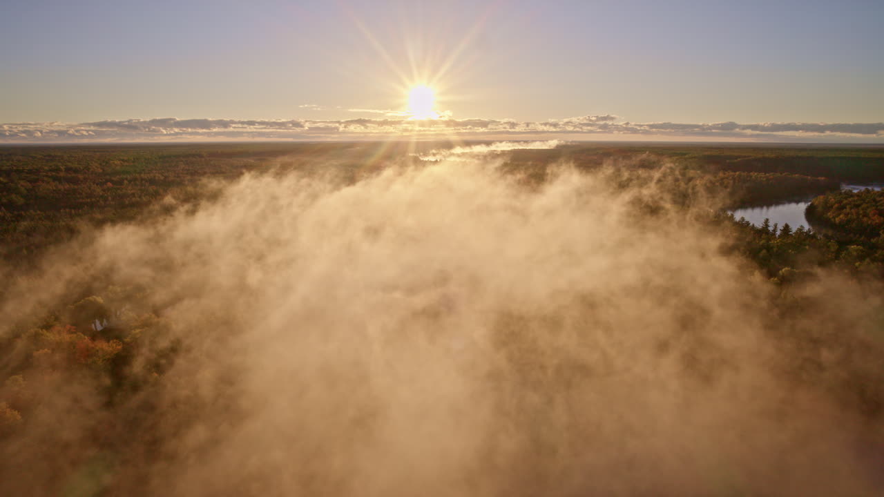 Cinematic aerial view of morning mist drifting above the water