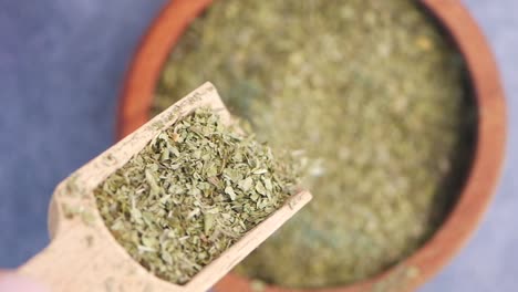 dried herbs in wooden spoon and bowl